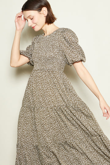 woman wearing a brown floral puff sleeve maxi dress with a flowing skirt