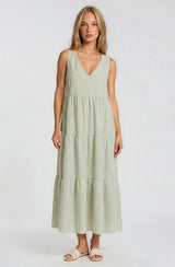 woman wearing a light green striped maxi dress with a V-neck and tiered skirt
