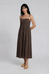 woman wearing a brown sleeveless midi dress with a gathered bodice and relaxed fit