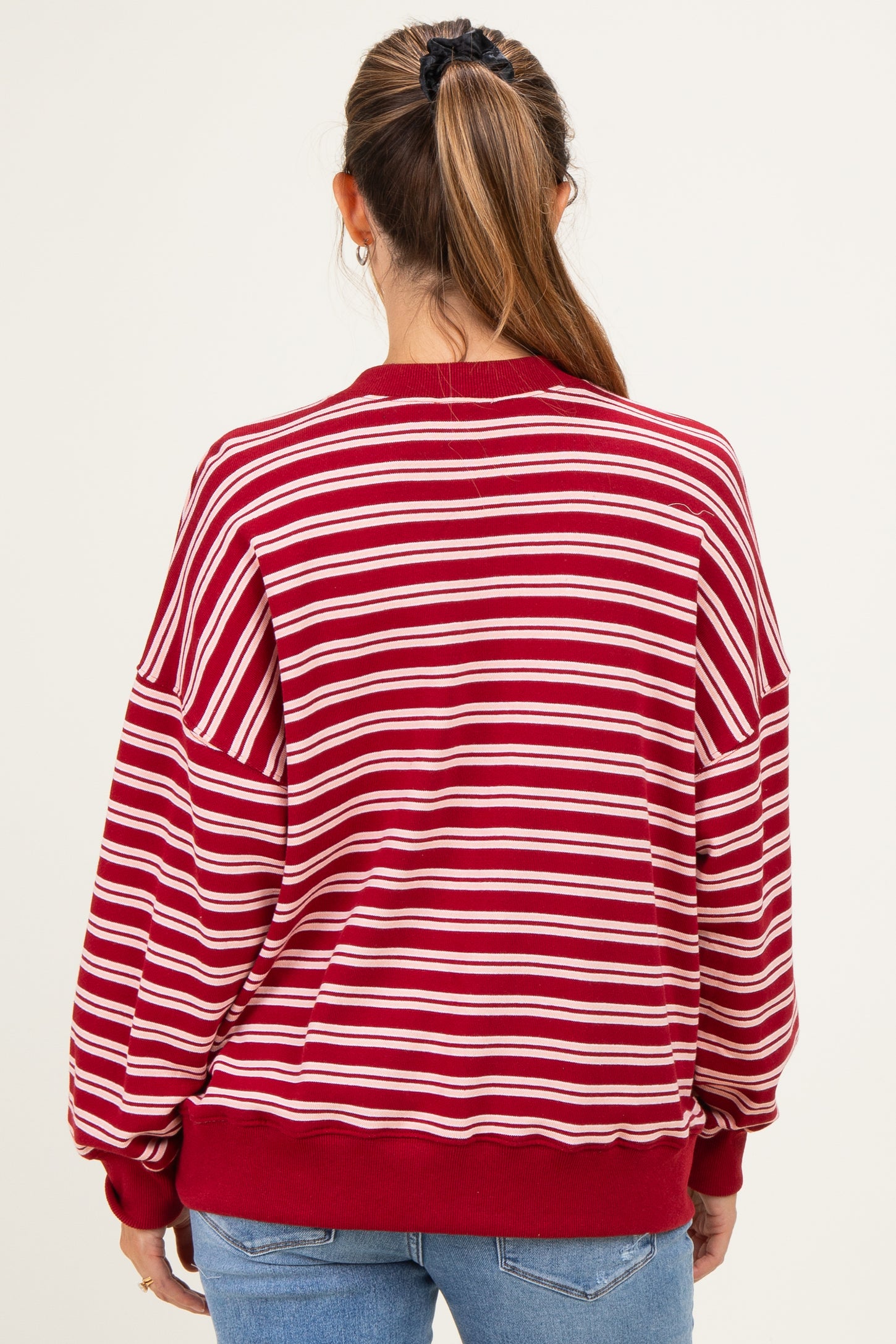 woman wearing a red and white striped maternity sweatshirt, showing the back view and relaxed fit