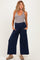 woman wearing a grey tank top and navy blue wide-leg maternity pants with pockets and a stretchy waistband