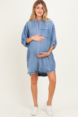 woman wearing a blue denim maternity dress with a button-up front and a visible baby bump
