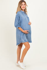 woman wearing a light blue denim maternity shirt dress with button details and a visible baby bump