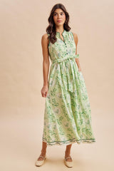 woman wearing a green floral sleeveless maxi dress with a tie waist detail