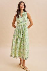 woman wearing a green floral maxi dress with a tie waist and button details