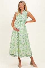woman wearing a green floral maternity dress with a tie waist and a visible baby bump