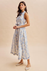 woman wearing a light blue floral print midi dress with a belted waist and a high neckline