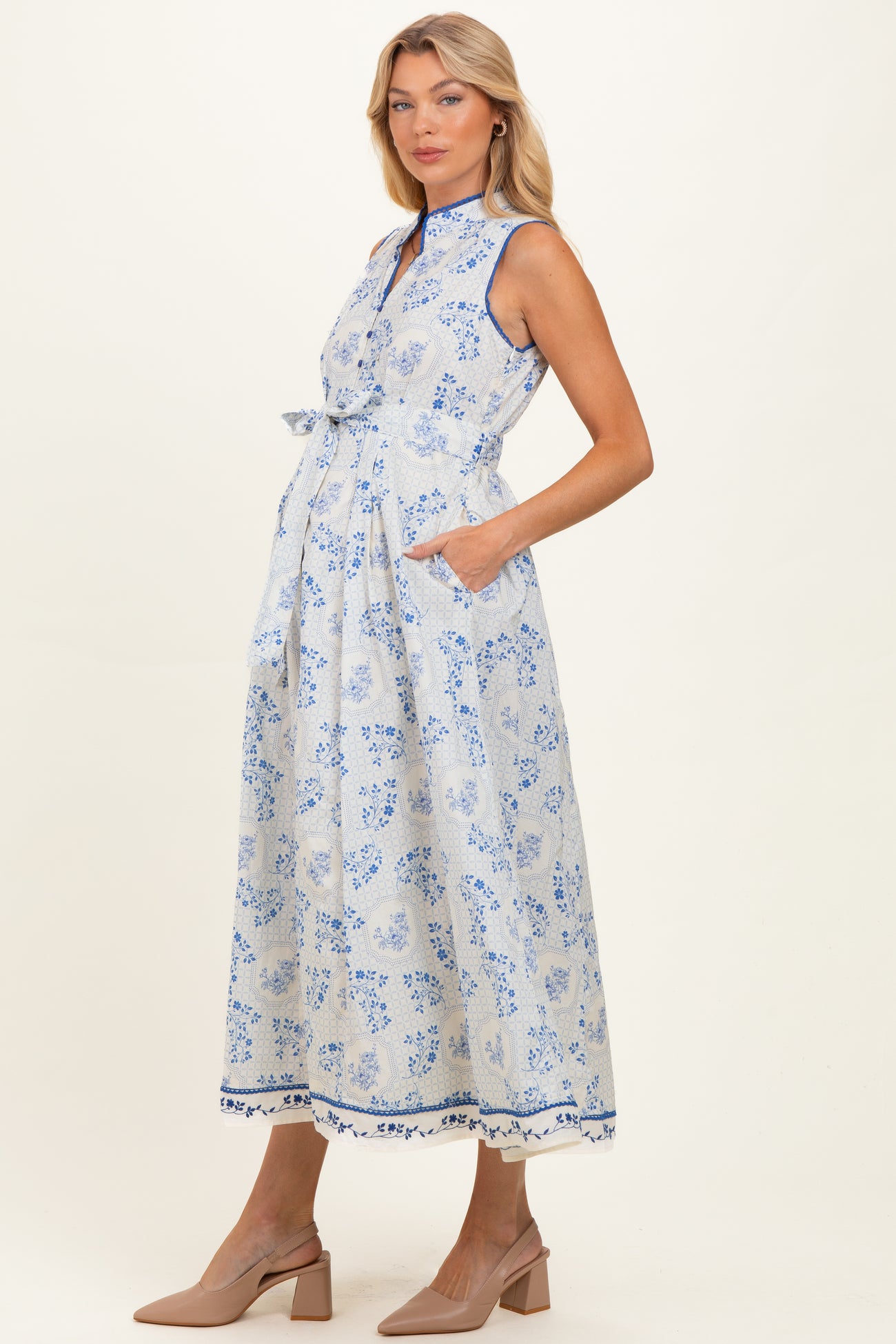 woman wearing a light blue floral print maternity maxi dress with a collar and pockets