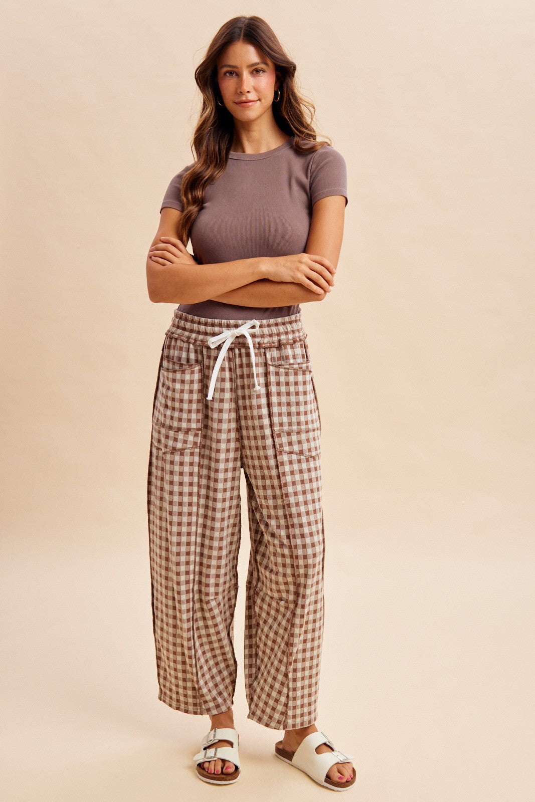 woman wearing a brown ribbed short sleeve top and beige plaid wide-leg pants with pockets and a drawstring waist