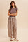 woman wearing a brown ribbed short sleeve top and beige plaid wide-leg pants with pockets and a drawstring waist