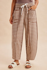 woman wearing brown and white gingham patterned wide-leg pants with an elastic waistband and side pockets