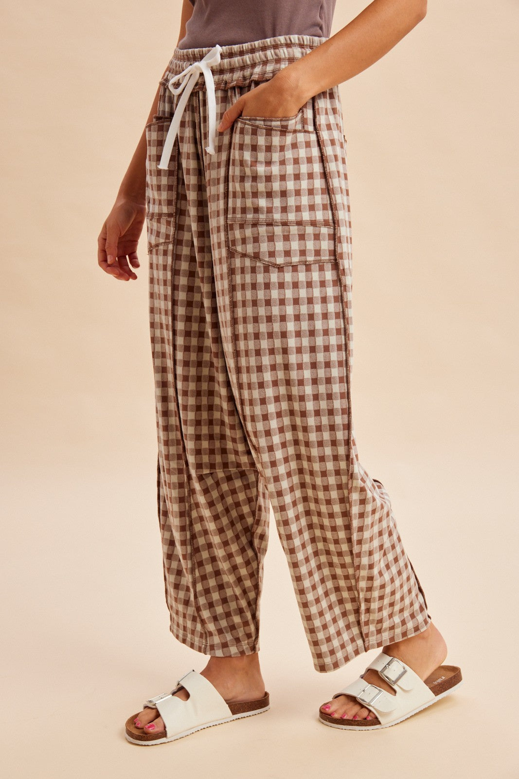 woman wearing brown and white checked lounge pants with side pockets and drawstring waist