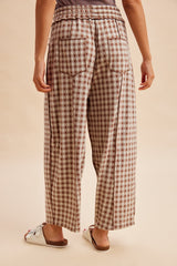 woman wearing brown and cream oversized checkered wide-leg pants, view from the back