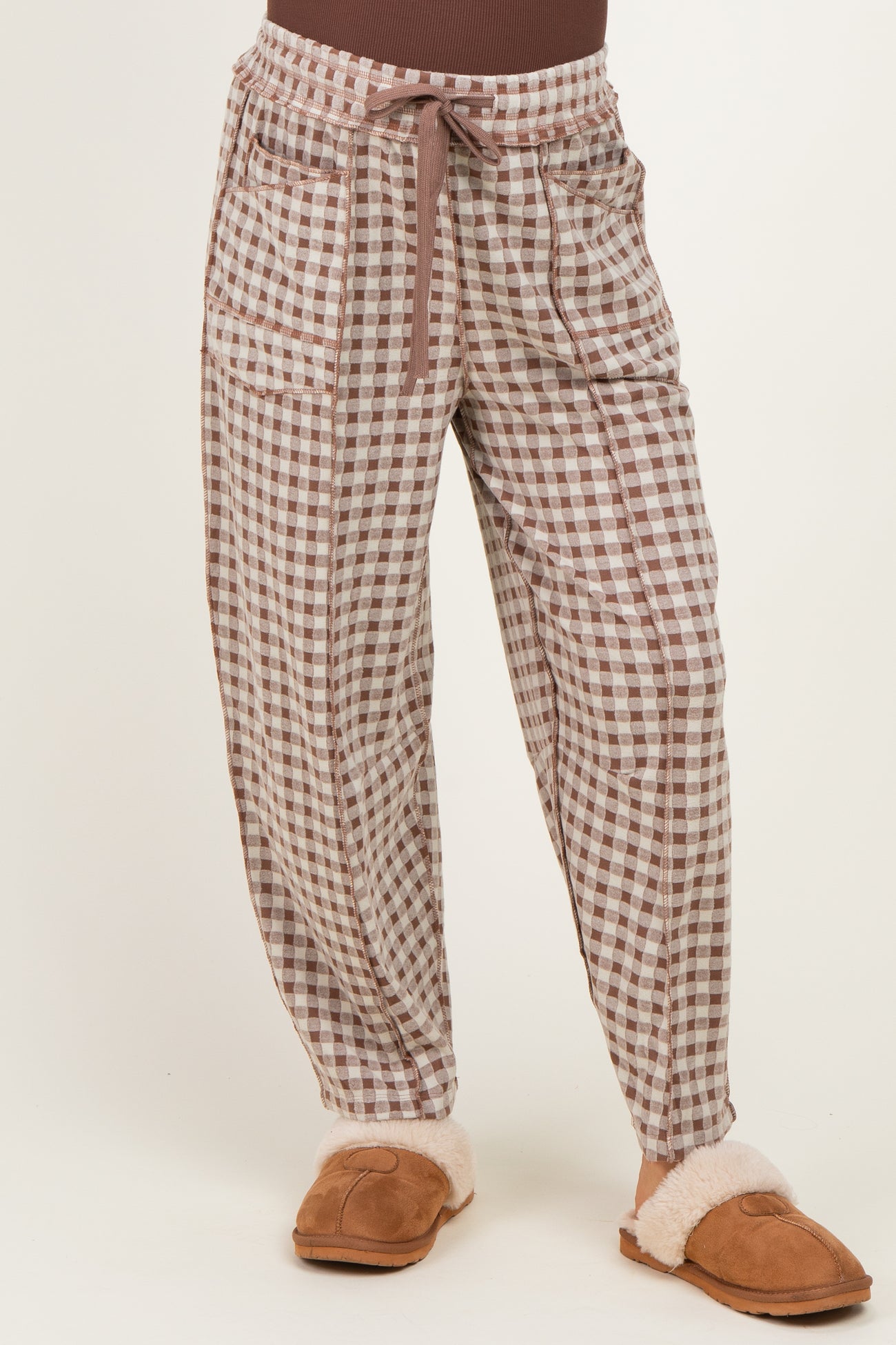 woman wearing brown and white checked maternity pants with a drawstring and side pockets