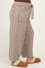 woman wearing brown and cream checkered maternity wide-leg pants with drawstring waist and side pockets