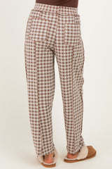 woman wearing brown and white checkered maternity lounge pants, showing the back view and styled with cozy slippers