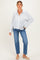 woman wearing a striped maternity button-up shirt with a front pocket and blue jeans