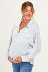 woman wearing a blue and white striped maternity button-up shirt and holding her baby bump