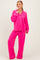 woman wearing a bright pink long sleeve pajama set with white piping and relaxed fit pants