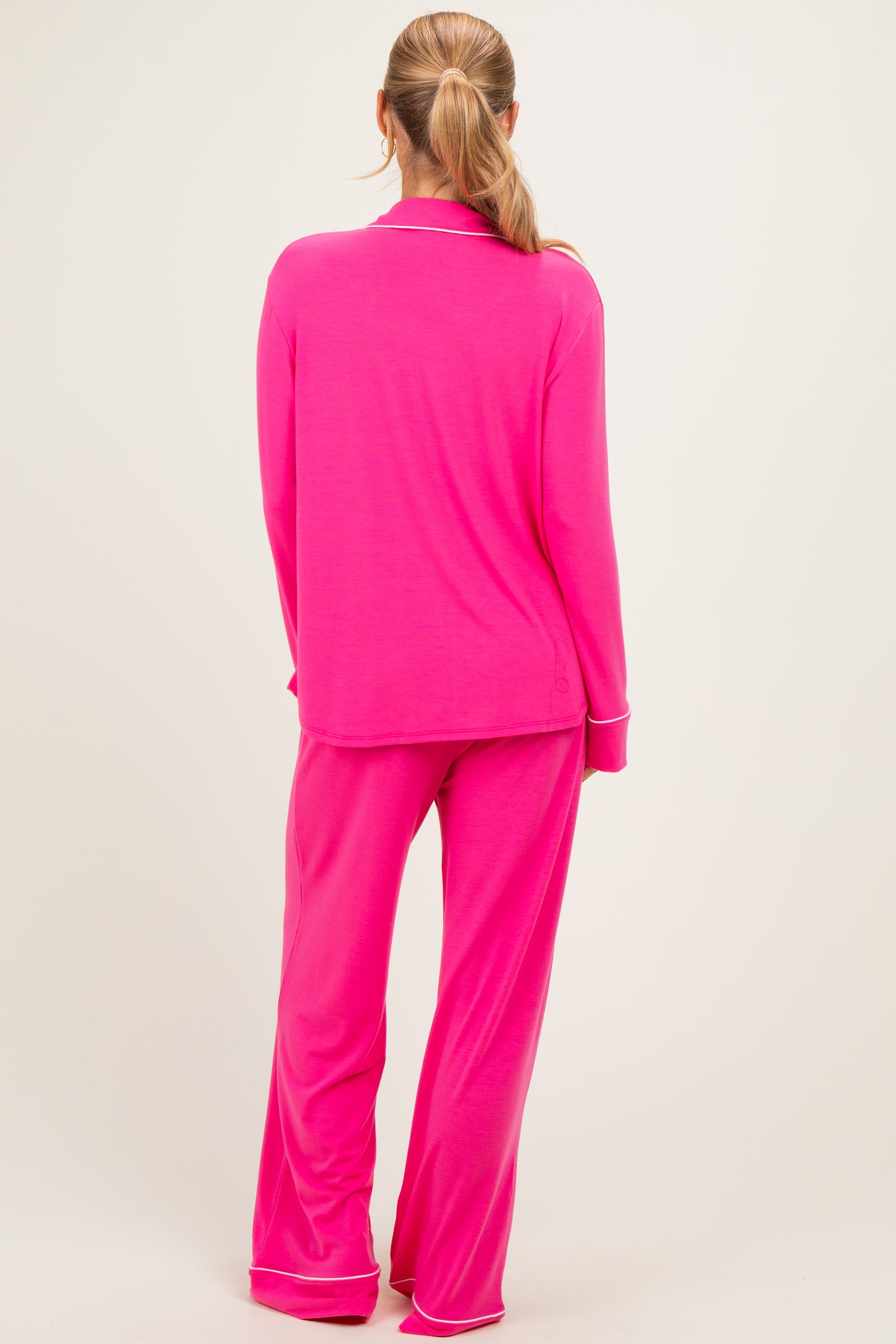 woman wearing a bright pink long sleeve pajama set with matching pants, view from the back