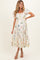 woman wearing a floral print maternity maxi dress with short puff sleeves and a tiered hemline