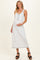 woman wearing a white maternity maxi dress with a decorative neckline and holding her baby bump