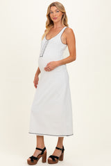 woman wearing a light gray maternity maxi dress with a scoop neckline and button details, highlighting her baby bump