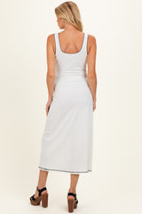 woman wearing a white ribbed maternity maxi dress with a scoop back and side slit, showing her baby bump