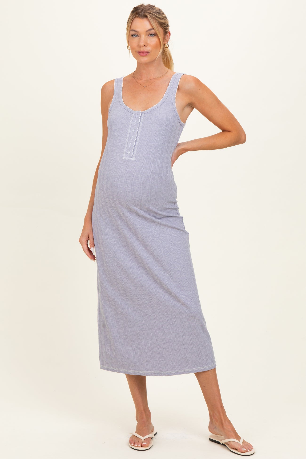 woman wearing a lavender maternity maxi dress with a scoop neckline and button details, showcasing her baby bump