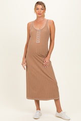 woman wearing a brown ribbed maternity maxi dress with decorative buttons and a baby bump visible