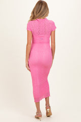 woman wearing a pink lace maternity dress with short sleeves and a fitted silhouette, showing a baby bump from the back
