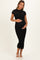 woman wearing a black lace maternity dress with short sleeves and holding her baby bump