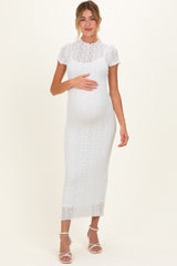 woman wearing a white lace maternity dress and holding her baby bump