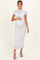 woman wearing a white lace maternity dress and holding her baby bump