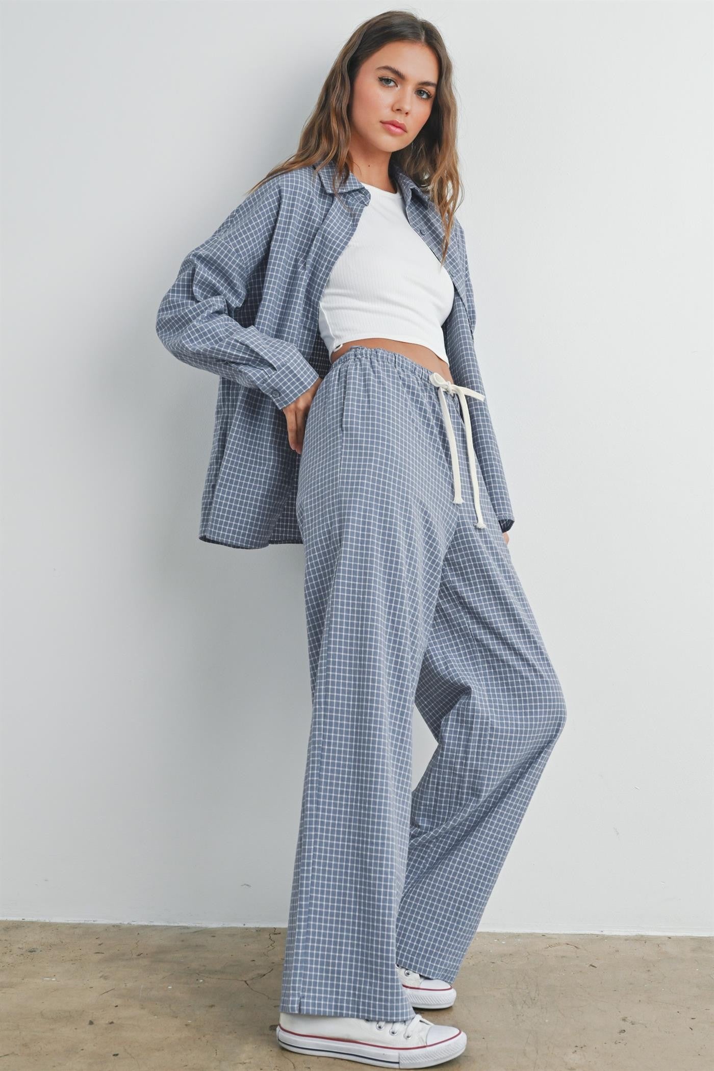 woman wearing a blue and white gingham check oversized shirt with matching pants and a white crop top