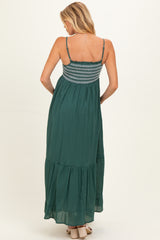 woman wearing a green maternity maxi dress with a smocked bodice and tiered skirt from the back