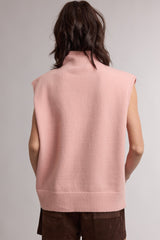 woman wearing a soft pink sleeveless turtleneck sweater with a relaxed fit, viewed from the back