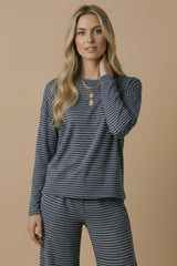 woman wearing a navy blue and white striped long sleeve top with matching pants, styled casually with a necklace