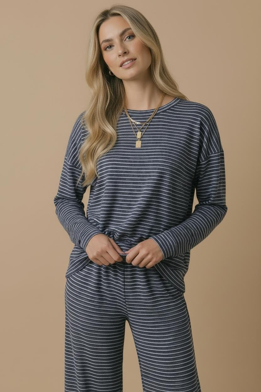 woman wearing a navy blue and white striped long sleeve top with a relaxed fit and matching wide-leg pants