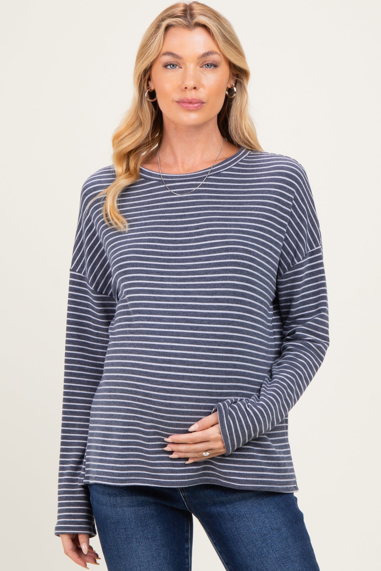 woman wearing a navy and white striped maternity top and showing her baby bump