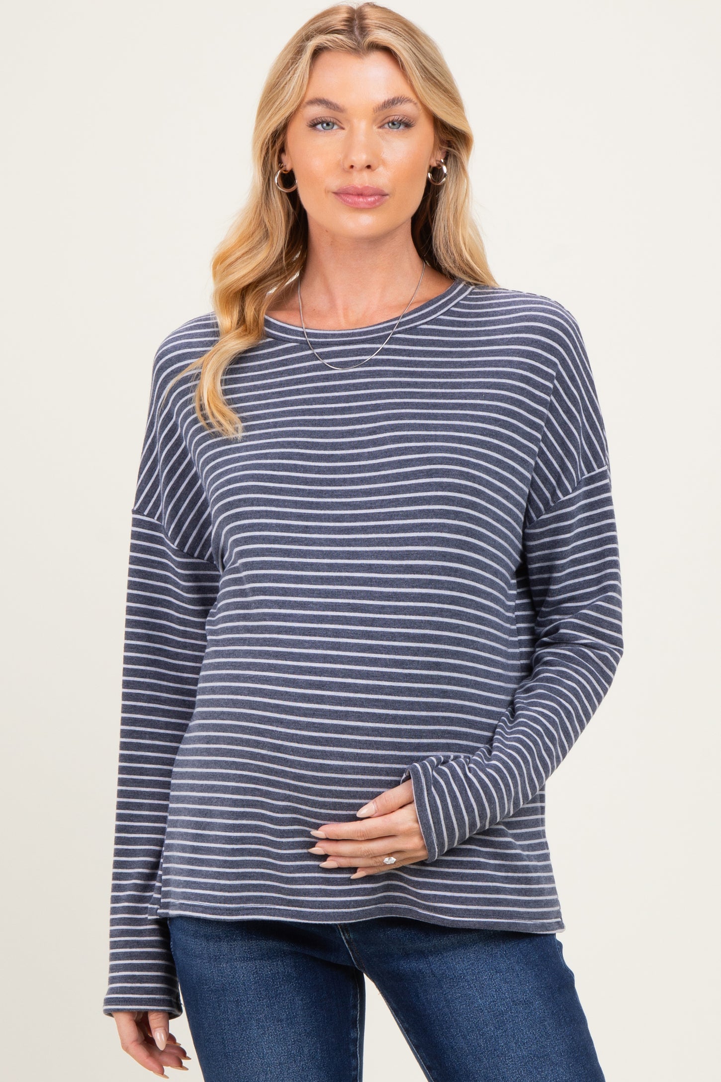 woman wearing a navy and white striped maternity top and showing her baby bump
