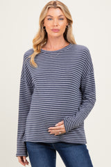 woman wearing a navy and white striped maternity top and showing her baby bump