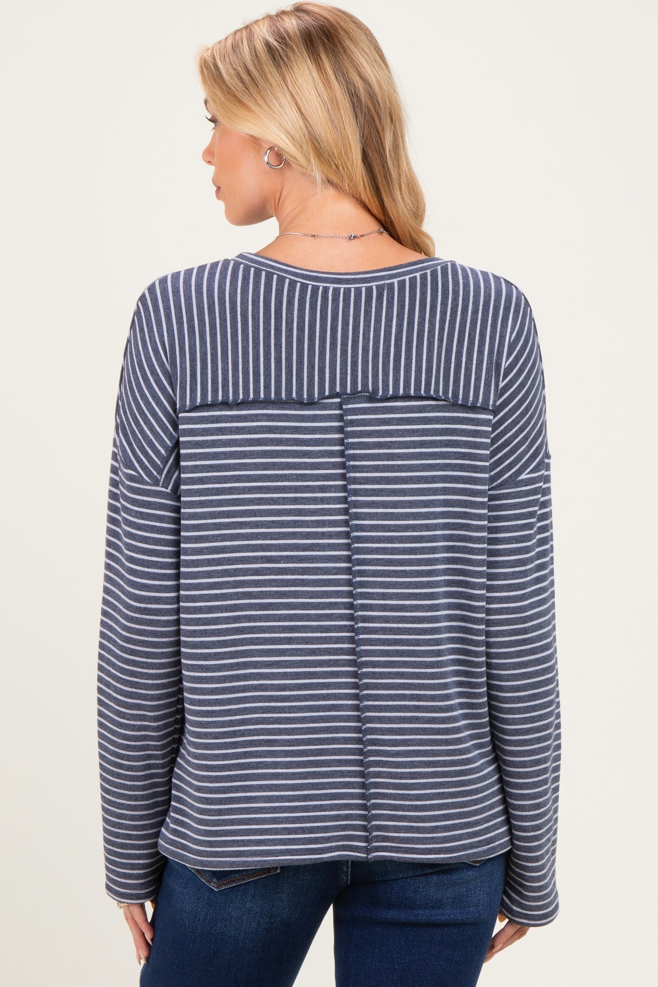 woman wearing a navy and white striped maternity top with a relaxed fit and back seam detail