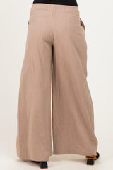 woman wearing light brown wide leg maternity pants with an elastic waistband and side pockets, viewed from the back