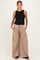 woman wearing a black sleeveless maternity top and beige wide-leg maternity pants with pockets
