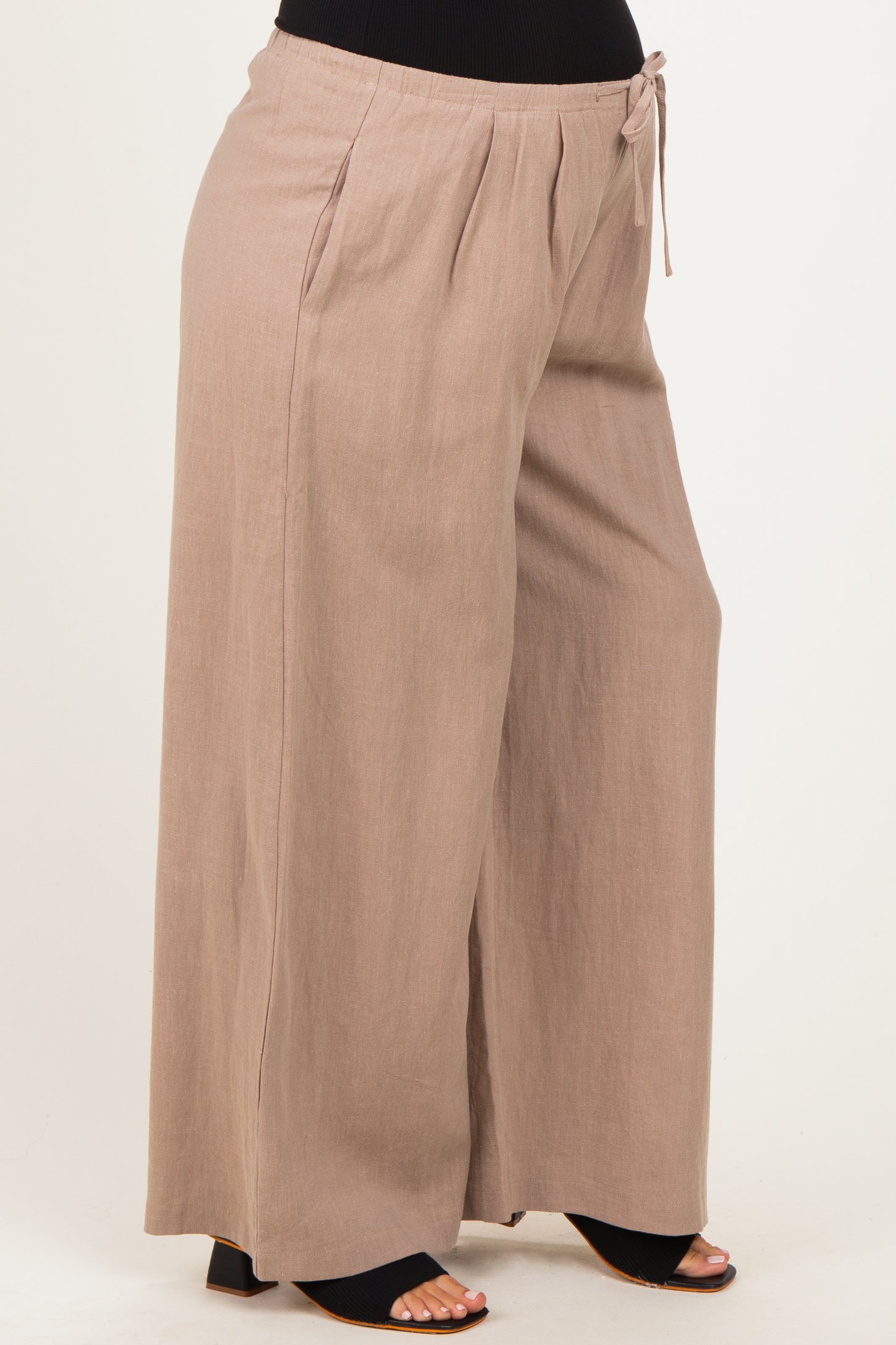 woman wearing beige maternity wide-leg pants with a drawstring waist and a relaxed fit