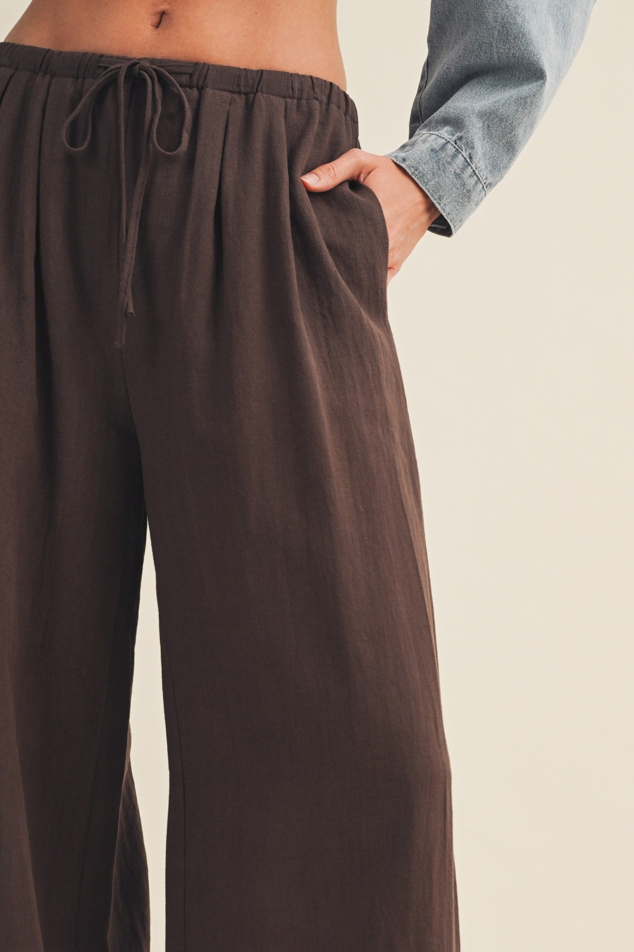 woman wearing dark brown wide-leg pants with an elastic waistband and side pockets