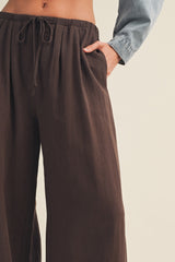 woman wearing dark brown wide-leg pants with an elastic waistband and side pockets