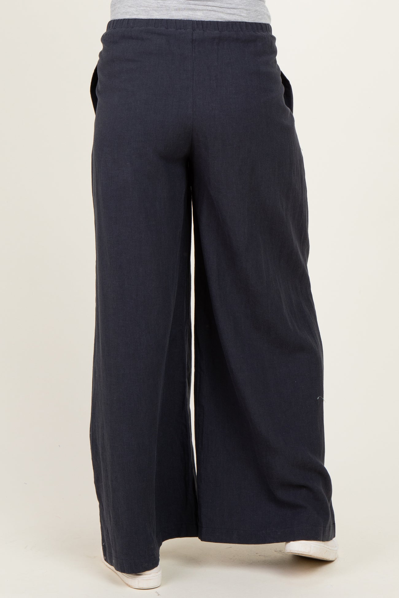 woman wearing navy blue wide-leg maternity pants with pockets, viewed from the back