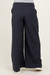 woman wearing navy blue wide-leg maternity pants with pockets, viewed from the back